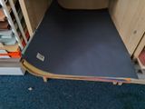 a blue mat on the floor next to a wooden cabinet