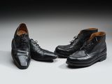 une paire de chaussures en cuir noir posée sur une surface blanche
