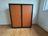 a cabinet in the corner of a room with wood floors