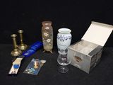 a box with a candle, a vase, a candle holder, and some other items on a table