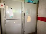 two refrigerators that are in a room with red and white tiles