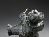 bronze figurine of a bear with a toothpick in its mouth