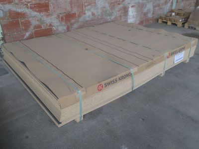une boîte en carton posée sur une palette devant un mur de briques