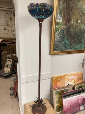 a lamp that is sitting on a table in front of a painting