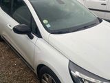 the white car is parked in front of a white building