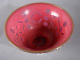a pink bowl with a gold rim sitting on a table