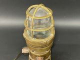 an antique brass plated light with a glass dome on a black surface