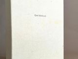 un vieux livre à la couverture blanche posé sur une table