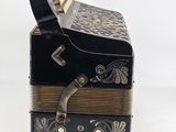 a black and gold accordion sitting on top of a white table