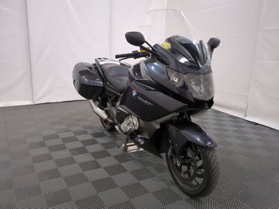une photo d'une moto noire garée sur un sol à damier