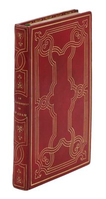 un vieux livre rouge aux tranches dorées, avec un motif décoratif sur la couverture