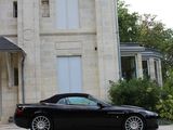 a black sports car parked in front of a large house