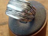 sterling silver ring on a wooden stand on a wooden surface