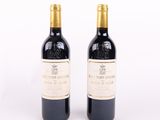 deux bouteilles de vin posées l'une à côté de l'autre sur une surface blanche