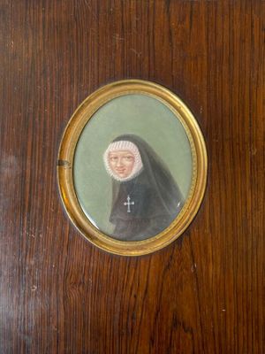 an old picture of a nun in a black robe with a cross on it