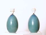 deux vases bleus posés sur une table blanche