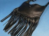 leather purse with fringes on a blue background