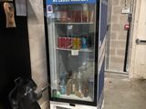 a nocco vending machine in a garage next to a pile of junk