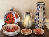 de nombreux vases et assiettes de toutes sortes sur la table