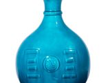 un vase bleu posé sur une surface blanche