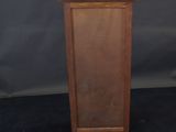 a small wooden cabinet with a door open on a black background