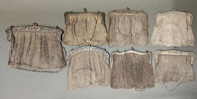 Plusieurs petits sacs à main sont alignés sur une surface blanche