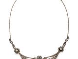 un collier en argent orné d'un motif floral sur une chaîne