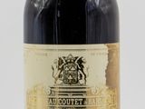 une vieille bouteille de vin posée sur une table blanche