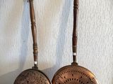 paire de poêles anciennes en cuivre avec des manches en bois