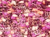 close up of a pink and white knitted blanket with flowers on it