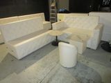 several white couches and tables in a room with a black wall