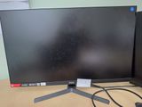 two computer monitors sitting on a desk next to each other