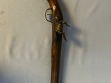 un vieux pistolet posé sur une surface blanche