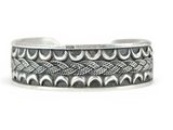 a close up of a silver cuff bracelet with a braid design
