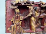 a red and gold plaque with a man and a woman on it