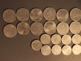 a lot of coins sitting on a table next to each other