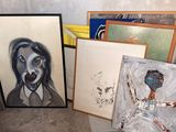 many paintings on the floor in a room
