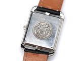 a close up of a watch on a white surface