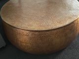 une table ronde avec un plateau en bois au milieu d'une pièce