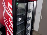 a coca cola machine in the corner of a room