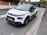 une petite voiture blanche garée sur le bord de la route