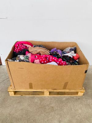 a cardboard box full of clothes on a pallet