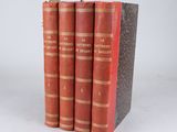 three red books sitting on top of each other on a white surface