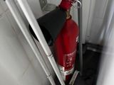 un extincteur rouge dans un coin de la salle de bains