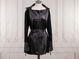 black leather coat on a mannequin stand in front of a white wall