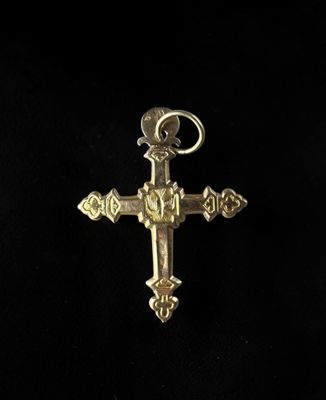 a gold cross with a bird on top of it on a black background