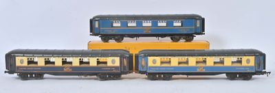 trois petits trains jouets empilés les uns sur les autres sur une surface blanche
