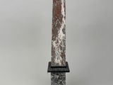 marble obelisk on a marble base with a black base