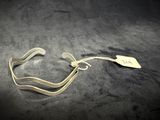 a silver bracelet with a tag on it on a black surface