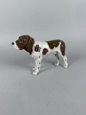 a figurine of a brown and white dog on a gray background